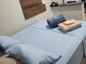 a bed with two towels sitting on top of it at Apartamento in União da Vitória