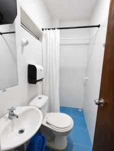 a bathroom with a white toilet and a sink at Hotel Playarena in Coveñas +21 photos