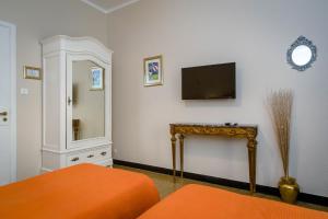 ジェノヴァにあるB&B I Portici Di Sottoripaのテレビ、ベッド、鏡が備わる客室です。