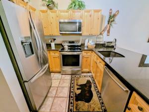 a kitchen with wooden cabinets and stainless steel appliances at Tenderfoot Lodge 2613 by SummitCove Lodging in Colorado in Keystone