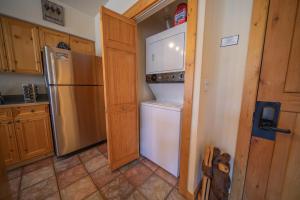a kitchen with a refrigerator and a door open at Tenderfoot Lodge 2620 by SummitCove Lodging in Colorado in Keystone