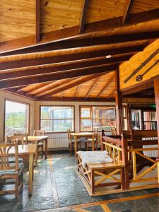 a room with wooden tables and chairs and windows at Ushuaia Lodge in Ushuaia