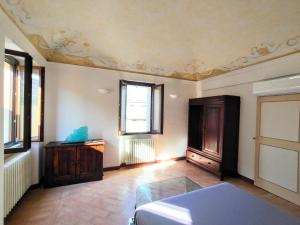a room with a bed and a dresser and windows at Apartment Monsignore, Pesaro in Pesaro