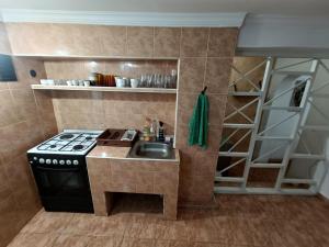 a small kitchen with a stove and a sink at Happy house in Kobuleti