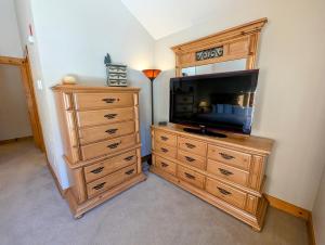 a living room with a tv and a dresser with a dresser at Trappers Crossing 8753 by SummitCove Lodging in Colorado in Keystone