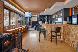 a bar in a restaurant with chairs and a television at Club Wyndham Shirakabaso Shigakogen in Yamanouchi