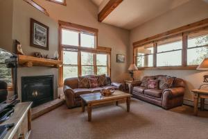 a living room with two couches and a fireplace at Trappers Crossing 8753 by SummitCove Lodging in Colorado in Keystone