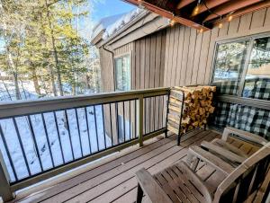 a porch with two chairs and a table and a table and chairs at Wild Irishman 1059 by SummitCove Lodging in Colorado in Keystone