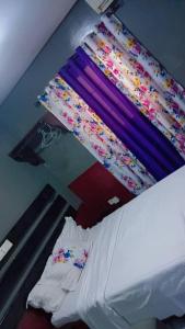 a bedroom with a bed with a canopy with flowers at Sunrise Lodging in Douala