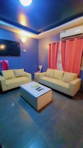 a living room with two couches and a table at Sunrise Lodging in Douala