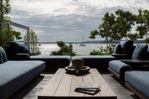 a living room with a couch and a table with a view of the water at Clay Beach Samui - Beachfront Villas in Bophut