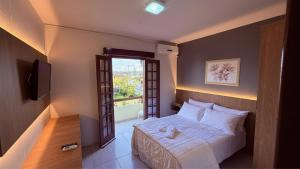 a small bedroom with a bed and a window at Rede Elevare Bella Vista in Florianópolis