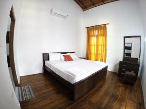 um quarto com uma cama grande e uma janela em Sunrise Cabanas em Baía de Arugam