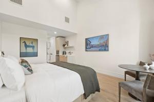 a white bedroom with a bed and a table at Casa Iglesia in Santa Barbara