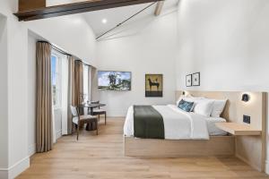 a bedroom with a large bed and a desk at Casa Iglesia in Santa Barbara