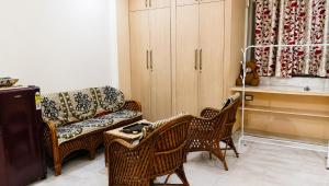 a living room with a couch and wicker chairs at Kasotiya Mansion Homestay in Surūrnagar