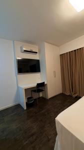 a room with a desk and a computer in it at Flat Suites Pampulha - AP 122 - Particular in Belo Horizonte