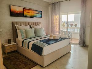 a bedroom with a large bed and a large window at Cozy apartment center, Larache in Larache