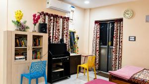 a room with a desk and chairs and a bedroom at Kasotiya Mansion Homestay in Surūrnagar