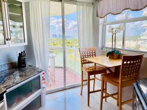 a kitchen with a table and chairs and a large window at Ocean & Bay Views 2BR 2BA Beach Condo! Parking in Miami Beach