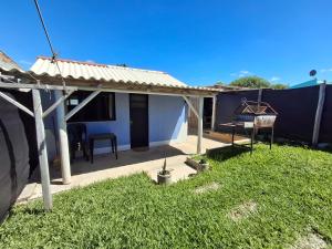 a small blue house with a grassy yard at Hospedaje El Rancho in Castillos