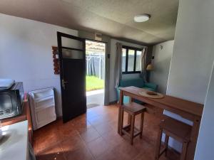 a small kitchen with a table and a door with a microwave at Hospedaje El Rancho in Castillos