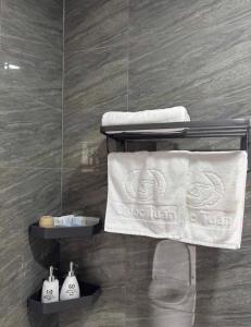 a bathroom with towels on a shelf in a room at Hotel QUỐC TUẤN in Ban Ay Dlă (2)