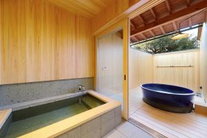 a bathroom with a large tub and a window at YASUYA-yasuya- in Yasugi