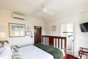 a bedroom with a bed and a ceiling fan at The Corner Hotel Alexandra in Alexandra