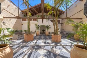 a courtyard with palm trees and chairs in a building at Casa Iglesia in Santa Barbara