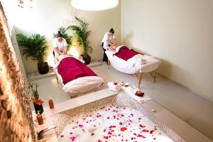 two men in a room with beds with flowers on the floor at Hotel Misión Comanjilla in Comanjilla
