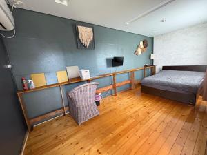 a bedroom with a bed and a wooden floor at 民宿あわい in Nakijin