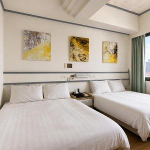 two beds sitting next to each other in a room at Fudi Hotel in Taichung