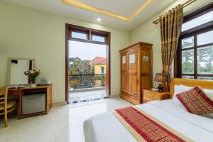 a bedroom with a bed and a desk and a window at Xuan Truong Central Dalat-1 min walk to Xuan Huong Lake in Da Lat