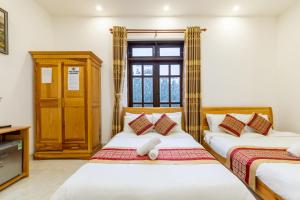 two beds in a room with a window at Xuan Truong Central Dalat-1 min walk to Xuan Huong Lake in Da Lat