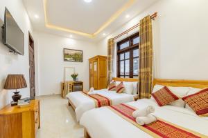 a bedroom with two beds and a television at Xuan Truong Central Dalat-1 min walk to Xuan Huong Lake in Da Lat +25 photos