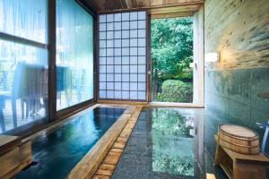 a house with a pool in the middle of a room at Onyado Satsuki in Tamana