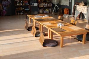 a wooden table and chairs with a wooden table and a table and chairsuggest at 民宿あわい in Nakijin