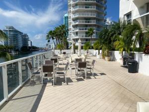 a patio with chairs and tables on a balcony at Ocean & Bay Views 2BR 2BA Beach Condo! Parking in Miami Beach