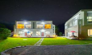a large building at night with a green yard at Chuncheon Venue Pool Villa August 19 in Chuncheon