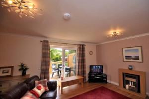 a living room with a couch and a television at Tarven Self Catering cottages in Portree