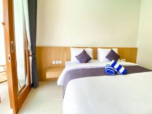 a bedroom with a bed with blue and white pillows at Casa de Ambalia in Uluwatu