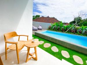 a chair and a table next to a swimming pool at Casa de Ambalia in Uluwatu +52 photos