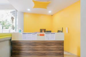 an office with a yellow wall and a counter at Hotel O Rest Inn in Yeraoda
