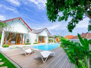 a villa with a swimming pool and two chairs at Casa de Ambalia in Uluwatu