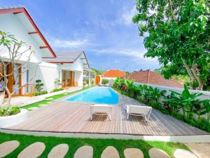 a backyard with a wooden deck and a swimming pool at Casa de Ambalia in Uluwatu