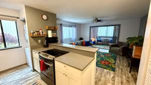 a kitchen with a counter and a living room at Holualoa Gardens 101 in Kailua-Kona