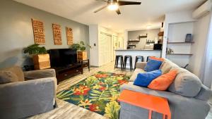 a living room with a couch and a kitchen at Holualoa Gardens 101 in Kailua-Kona
