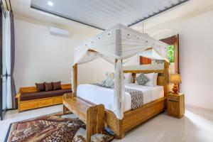 a bedroom with a canopy bed and a couch at Ubud Mesari Private Pool Villa in Ubud +43 photos