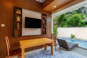 a living room with a table and a swimming pool at Ubud Mesari Private Pool Villa in Ubud
